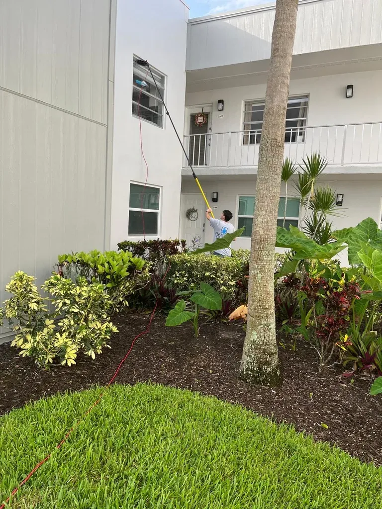 Gulfshine technician cleaning second-story windows