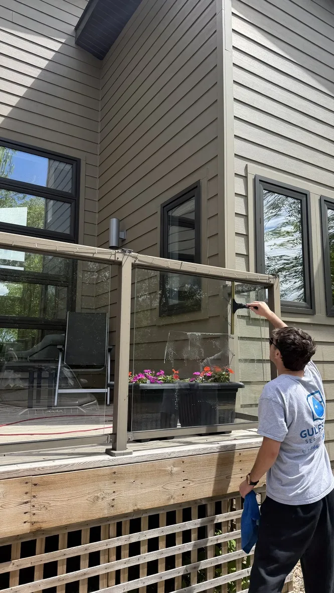 Gulfshine technician cleaning exterior glass